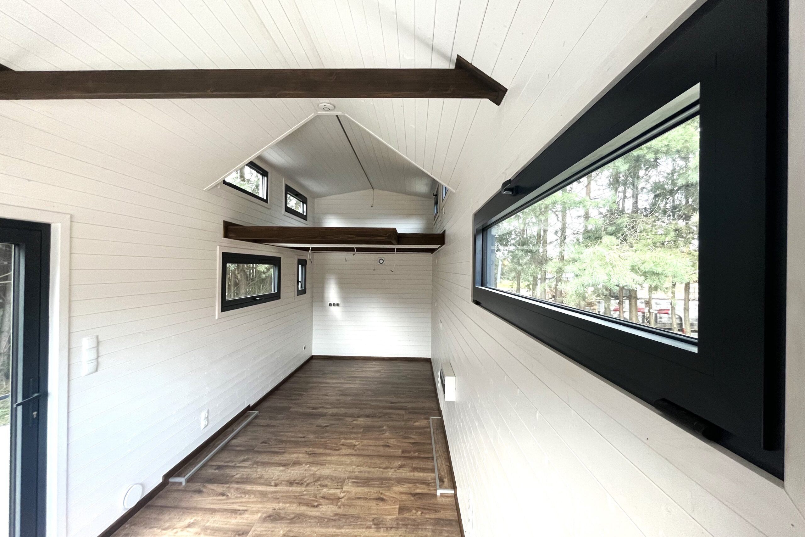 Tiny house grise extérieur, intérieur blanc : une élégante résidence compacte aux couleurs contrastées, parfaite pour le minimalisme chic et la vie confortable.